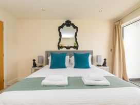 A bedroom with a bed and mirror at Whitewater Seaview in Newquay