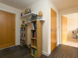 A hallway with a bookcase and decorative items at Whitewater Seaview in Newquay
