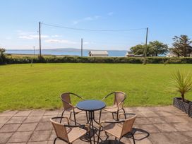 A garden with a table and chairs overlooking the sea at The Boathouse, Carrigaholt, County Clare
