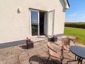 An outdoor area with chairs and a table at The Boathouse in Carrigaholt, County Clare