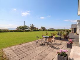 A garden with a table and chairs on a patio at The Boathouse in Carrigaholt, County Clare
