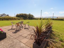 An outdoor seating area with a table and chairs at The Boathouse in Carrigaholt, County Clare