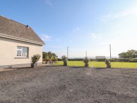 An outdoor area with a house and planters at The Boathouse in Carrigaholt, County Clare