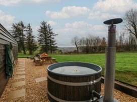 An outdoor space with a hot tub and seating area at Willow in Llangurig near Llanidloes