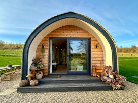A cabin entrance with wooden decking and decorative items at Willow in Llangurig near Llanidloes