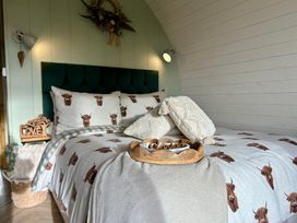A bedroom featuring a bed with patterned bedding and decorative pillows at Willow in Llangurig near Llanidloes