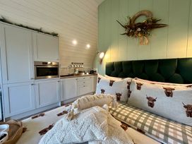 A living room with a sofa and kitchen cabinets at Willow in Llangurig near Llanidloes