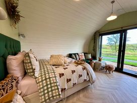 A bedroom with a bed and sliding doors at Willow Llangurig near Llanidloes