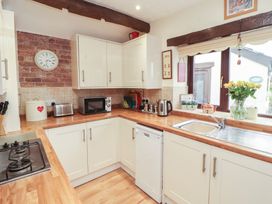 A kitchen with appliances and a window at River Cottage Eamont Bridge