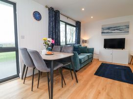 A living room with a dining table and sofa at Cassia in Kilkhampton