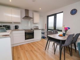 A kitchen with appliances and dining area at Cassia in Kilkhampton