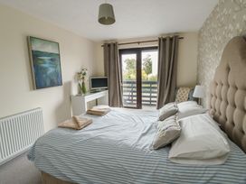 A bedroom with a bed and a television at Ty Haf in Trearddur Bay