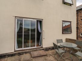 An outdoor area with a sliding door and seating at Flodden Apartment in Wooler