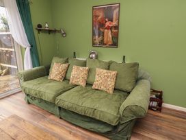 A living room with a green sofa and wall art at Flodden Apartment in Wooler
