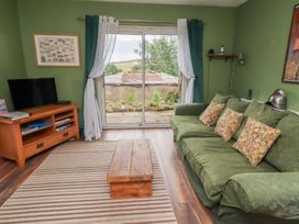 A living room with a television and sofa at Flodden Apartment in Wooler