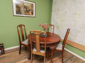 A table with chairs and a vase of flowers at Flodden Apartment in Wooler