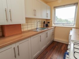 A kitchen with cabinets and sink at Flodden Apartment in Wooler