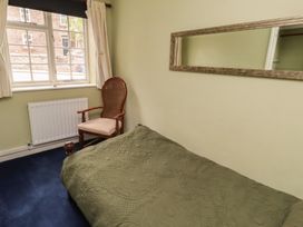 A bedroom with a bed and a chair at Flodden Apartment in Wooler