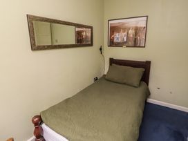 A bedroom with a bed and mirror at Flodden Apartment in Wooler