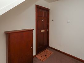 A hallway with a front door and a storage cabinet at Flodden Apartment in Wooler