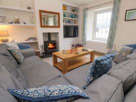 A living room with a fireplace and television at Fair View St Just in Roseland near St Mawes