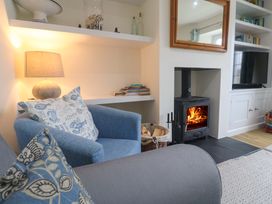 A living room with a fireplace and shelves at Fair View St Just in Roseland near St Mawes