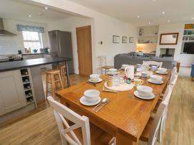A kitchen and dining area with a table set for meals at Fair View St Just in Roseland near St Mawes