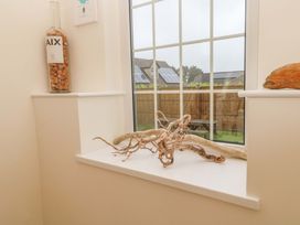 A window with a bottle and driftwood on the sill at Fair View St Just in Roseland near St Mawes