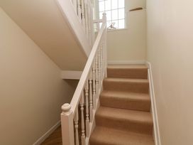 A staircase with carpet and a handrail at Fair View in St Just in Roseland near St Mawes