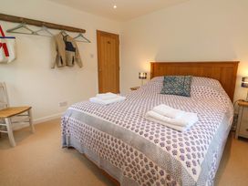 A bedroom with a bed and a chair at Fair View St Just in Roseland near St Mawes