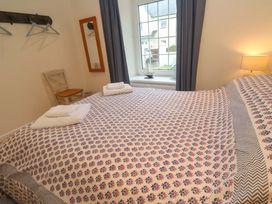 A bedroom with a bed and chair at Fair View St Just in Roseland near St Mawes