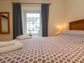 A bedroom with a bed and curtains at Fair View in St Just in Roseland near St Mawes