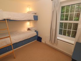 A bedroom with bunk beds and a window at Fair View in St Just in Roseland near St Mawes