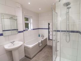 A bathroom with a shower, bathtub, and sink at Fair View St Just in Roseland near St Mawes
