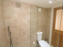 A bathroom with a shower, toilet, and door at Fair View, St Just in Roseland near St Mawes