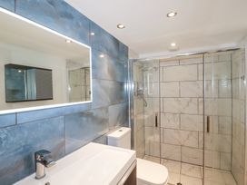 A bathroom with a sink and faucet toilet and a glass enclosed shower at The Cubby Hole in Sennen Cove