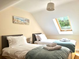 A bedroom with two single beds with towels on blue covers and a window in the ceiling at Penpraze in Portreath