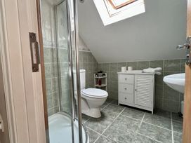 A bathroom with a shower enclosure toilet sink and white cabinet at Penpraze in Portreath