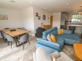 A living room with a sofa and dining area at Carnon Gwel, Devoran