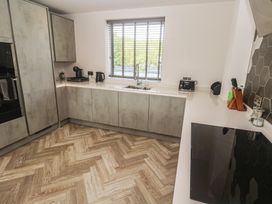A kitchen with cabinets, sink, kettle, and toaster at Carnon Gwel, Devoran