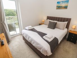 A bedroom with a bed and sliding door at Carnon Gwel, Devoran