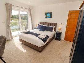 A bedroom with a bed and bedside table at Carnon Gwel, Devoran