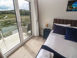 A bedroom with a bed and a sliding door at Carnon Gwel, Devoran