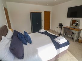 A bedroom with a bed and wardrobe at Carnon Gwel, Devoran