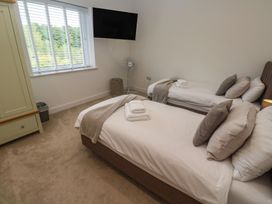 A bedroom with twin beds and a television at Carnon Gwel, Devoran