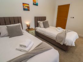 A bedroom with two single beds and a lamp at Carnon Gwel, Devoran