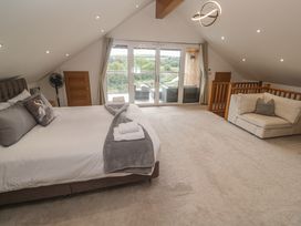 A bedroom with a bed and terrace access at Carnon Gwel, Devoran
