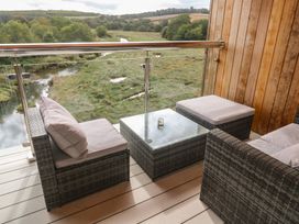 A balcony with seating area and a view of the river at Carnon Gwel, Devoran