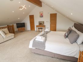 A bedroom with a bed and sofa at Carnon Gwel, Devoran