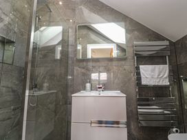 A bathroom with a shower, sink, and towel rack at Carnon Gwel, Devoran
